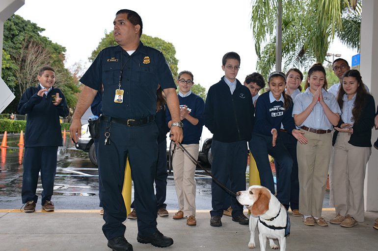 U.S. Customs Officer Alberto Gonzalez and his K-9 show off their skills for St. Mark students.