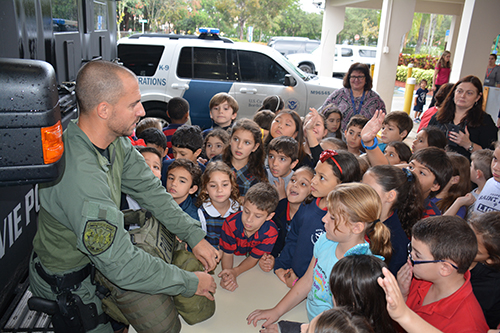 An officer from the Davie Police SWAT team speaks to St. Mark students.