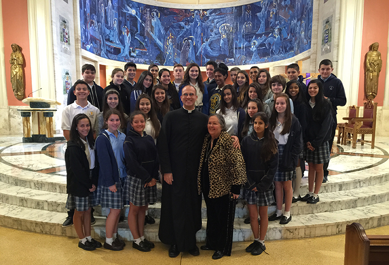 A group of Sts. Peter and Paul students pose in the sanctuary of St. Mary Cathedral with Father Christopher Marino, the cathedral's rector, and Carlota Morales, Sts. Peter and Paul's principal.