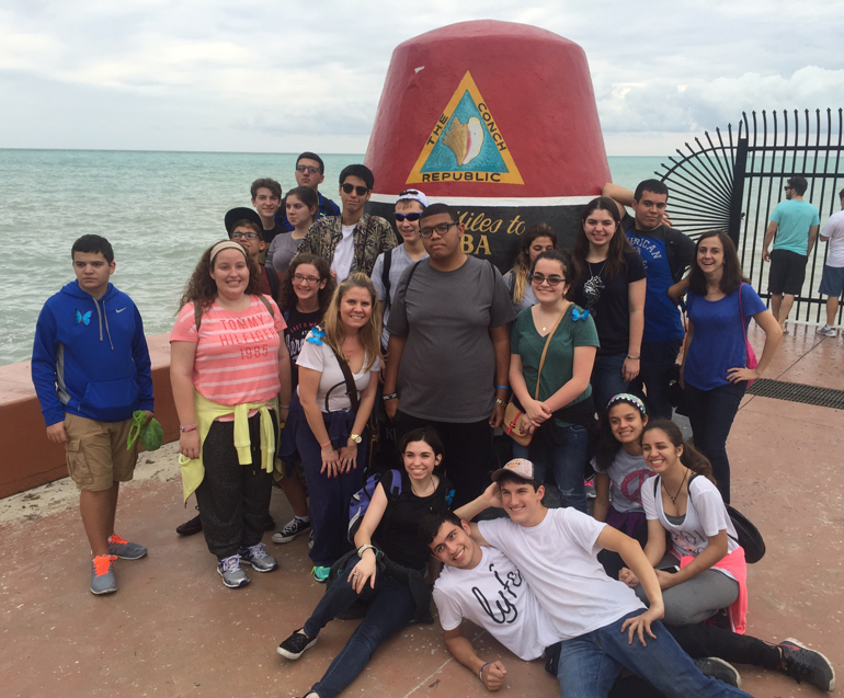 To the Southernmost Point: St. Brendan High teachers Daisy Cruz and Susana Gallarreta pose students from the Champagnat Program at the historical Florida landmark. The group journeyed to the Keys as an extension of interdisciplinary learning.