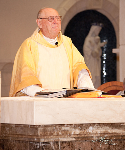 Msgr. Noel Fogarty prays at altar during his last Mass as pastor of St. Gregory the Great Parish in Plantation.