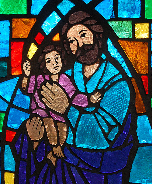 St. Joseph nurtures the young Jesus, in an image that has become more popular in churches over recent years. The image is on a stained glass window at St. Henry Church, Pompano Beach.