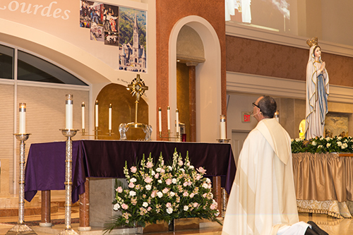 Msgr. Kenneth Schwanger, pastor of Our Lady of Lourdes, prays during the exposition and adoration of the Blessed Sacrament, part of the virtual pilgrimage to Lourdes that he brought to his parishioners.