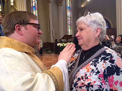 Holy Cross Father Matthew Hovde blesses his former youth minister, Susan Vanderwyden, after his ordination.