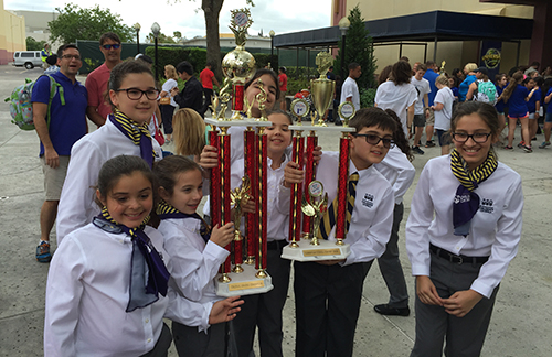 Members of St. Bonaventure's Children's Chorale hold up some of their championship hardware.