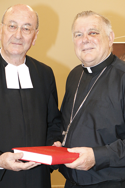 El Hno. Rodolfo Meoli, postulador de la causa del Hno. Victorino, le entrega una copia del "positio" a Mons. Thomas Wenski, arzobispo de Miami.