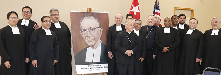 Los Hermanos De La Salle se toman una foto con el obispo emérito auxiliar de la Habana, Mons. Alfredo Petit, y el Arzobispo Thomas Wenski, quien visitó el salón parroquial de St. Agatha al finalizar la presentación.