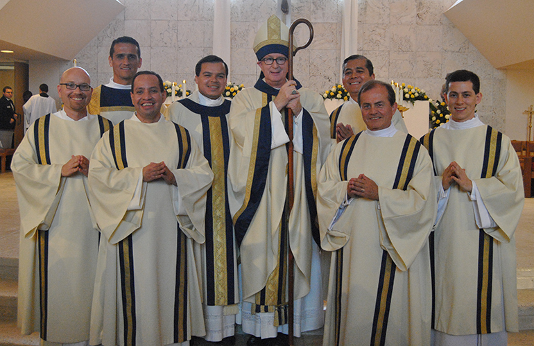 Posing with vocations director Father Elvis Gonzalez and Bishop John Noonan of Orlando after their ordination are the six new transitional deacons for Miami, from left: Deacon Luis Pavon, Deacon Juan Salazar, Deacon Luis Flores, Father Gonzalez and Bishop Noonan, Deacon Gary Delos Santos, Deacon Oswaldo Agudelo and Deacon Alex Rivera.