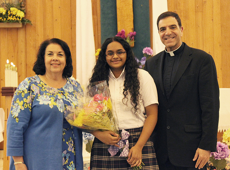 Hope Alex, Grand National Champion in the Zaner-Bloser National Handwriting Contest, poses with her principal, Kristen Hughes, and St. Andrew's pastor, Msgr. Michael Souckar.