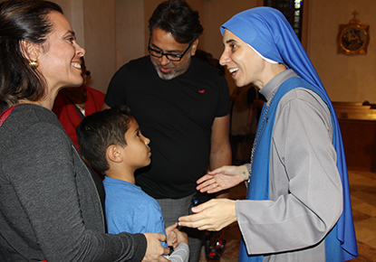 Andrea Garay, her husband, Rafa Herrera, and their son, Gabriel Herrera, members of St. Stephen Parish in Miramar, greet Sister Maria de Guadalupe Rodrigo after her talk at St. Patrick, Miami Beach.