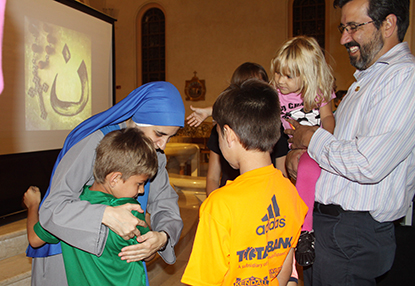 La Hna. Guadalupe Rodrigo, abraza a Rico Borjon, mientras sus hermanos Leonardo y Victoria y su padre Ricardo Borjon los miran, después de escuchar la presentación de la Hermana Guadalupe, en la parroquia St. Patrick, en Miami Beach.