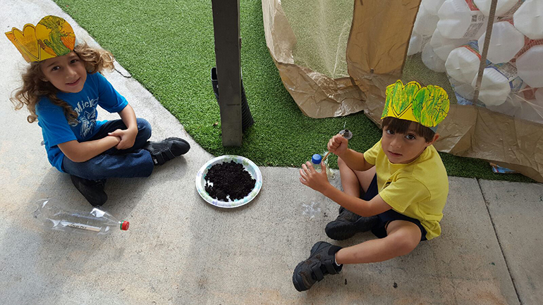 Waiting for the go-ahead to fill their bottles on Earth Day, from left, St. Michael preK3 students Elena Infante and Sabrian Fernandez.