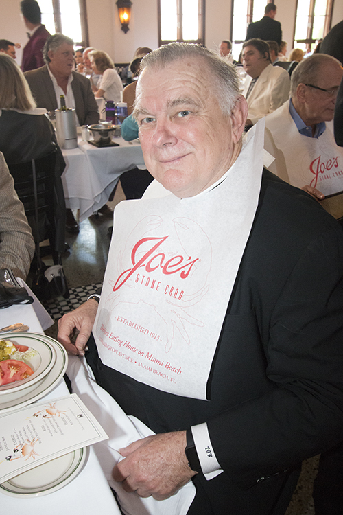 Archbishop Thomas Wenski wears the iconic Joe's bib for eating stone crabs.