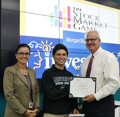 Andres de la Fé, a senior at Archbishop Edward A. McCarthy High School, receives a certificate acknowledging his first place win in the Florida High School InvestWrite student essay competition from Kevin Lydon, associate vice president and financial advisor for Morgan Stanley. At left is Kim Zocco, business and entrepreneurship teacher at Archbishop McCarthy High.