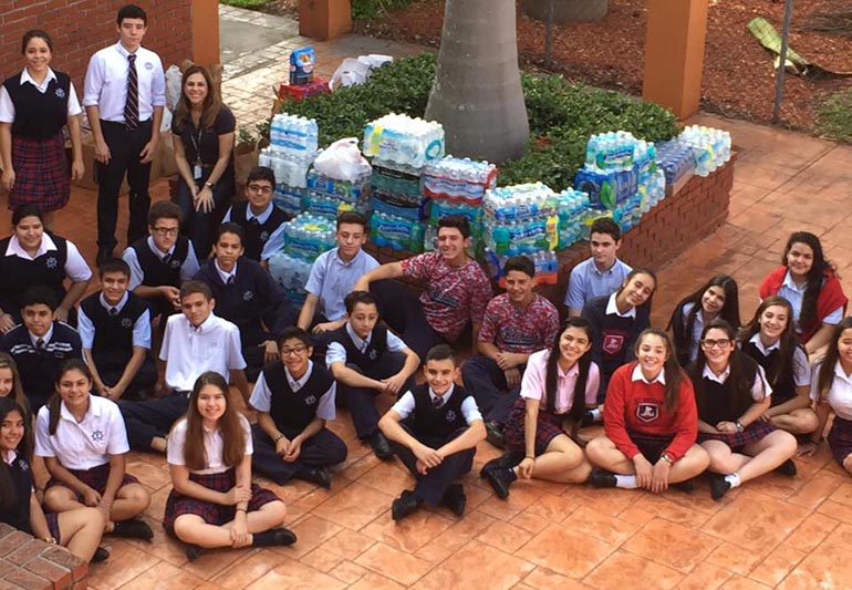 St. Brendan Elementary students take a quick break from counting and sorting supplies to help Ecuador recover from the earthquake. Cases of water, canned goods, and other items were collected by St. Brendan Elementary students, faculty and community.