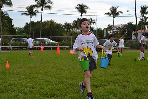 Daniel Roads, 5, a pre-k4 student at St. Theresa School, carries buckets of water during the fundraising event at the school.