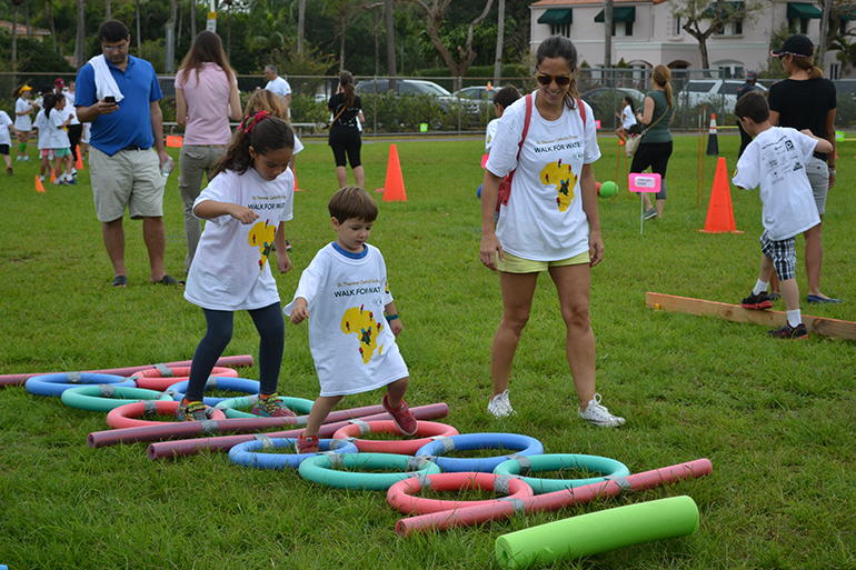 Simon Degano jumps through the pre-school obstacles as Eleonora Barlaro looks on.