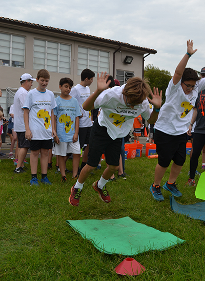 From left: St. Theresa School fourth-graders John Thorsell-Pantin and Massino Napolitano overcome an obstacle during the Walk for Water for Kazai.