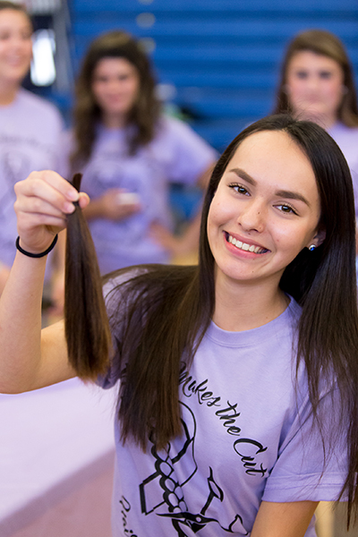 St. Thomas Aquinas High School student Emily Patton shows off her clipped ponytail during an April 29 after-school student hair cut and donation project called Pantene Beautiful Lengths, providing free wigs for those battling cancer. More than 800,000 ponytails have been donated to date nationwide.