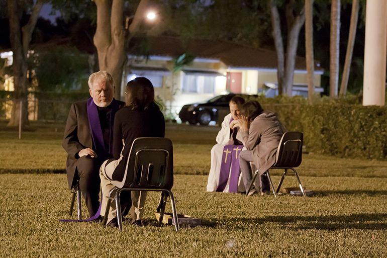 Father Curtis Kiddy, pastor of St. Jerome in Fort Lauderdale, hears confessions on the grounds of Blessed Trinity Church during Mercy Night, part of Blessed Trinity's Easter Mission May 6. A dozen priest were on hand to hear confessions throughout the evening.