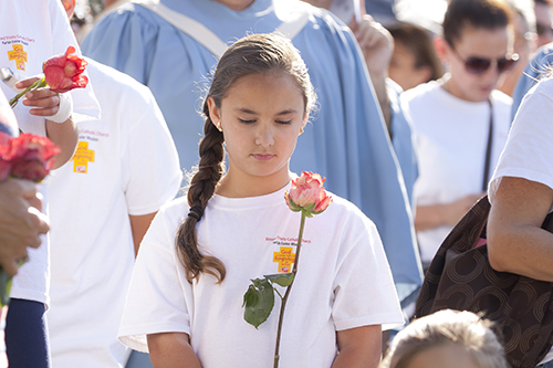 Isabella Travieso holds a rose while in solemn reflection before the start of the Blessed Trinity Parish Easter Mission Mass. The Mass took place at the Miami Springs Circle and was celebrated by Archbishop Thomas Wenski.