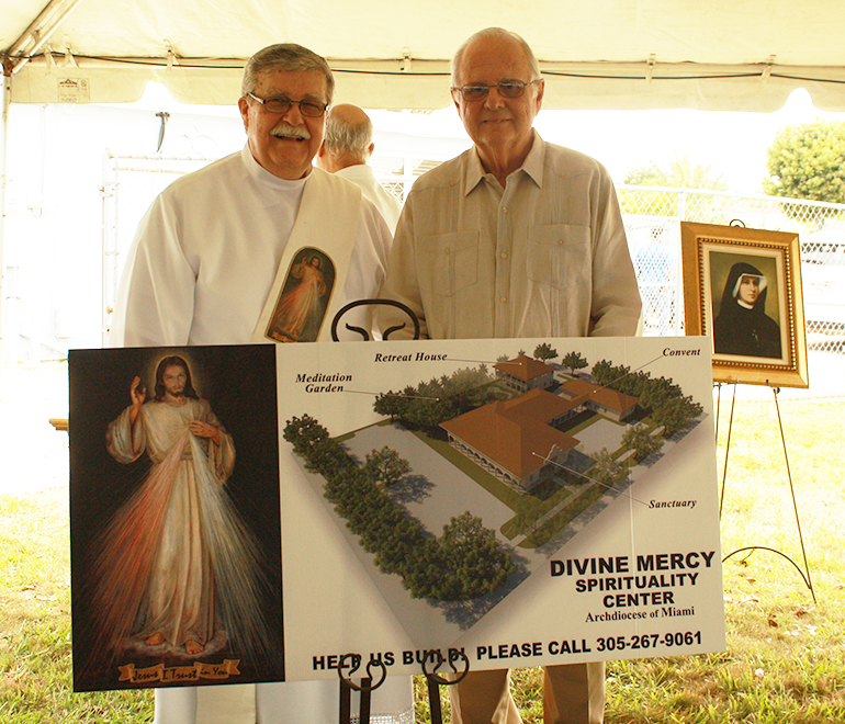 Deacon Rafael de los Reyes, left, spiritual director of Apostolate of Divine Mercy in the Archdiocese of Miami, and David J. Cabarrocas, architect of the project, pose in front of a rendering of the future Divine Mercy Sanctuary and Convent in Miami.