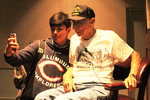 A Columbus High School student takes a selfie with World War II vet Todd Silverman, thanking him for his service.