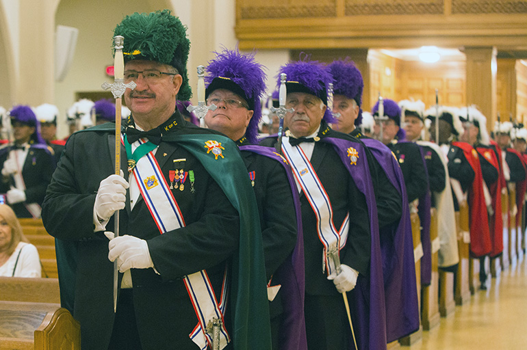 Knights of Columbus Florida District Vice-Marshall Jim Kelly, head of the fourth-degree honor guard, stands at the front of a long line of Knights as Archbishop Thomas Wenski blesses their swords during a special ceremony at St. Mary Cathedral.