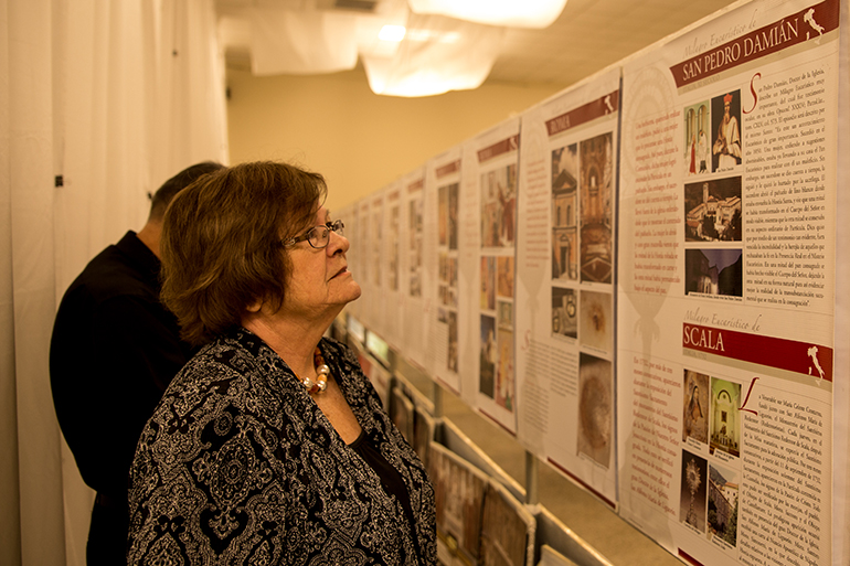 A parishioner of St. Thomas the Apostle reads about the different miracles of the world during the exhibit at the parish, which took place the weekends of May 14-15 and 21-22.