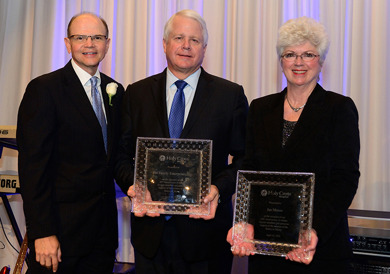 Holy Cross Hospital President and CEO Dr. Patrick Taylor, left, gives a plaque of recognition to JM Family Enterprises President and CEO Colin Brown and Jan Moran, widow of automotive pioneer Jim Moran.