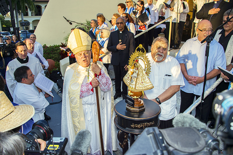 El Arzobispo Thomas Wenski y el P. José Joaquín Espino cantan a la Virgen de la Caridad del Cobre, durante el recibimiento de la imagen peregrina en la Ermita de la Caridad. Su llegada coincidió con la celebración del centenario de la proclamación de la Virgen de la Caridad del Cobre como Patrona de Cuba.
