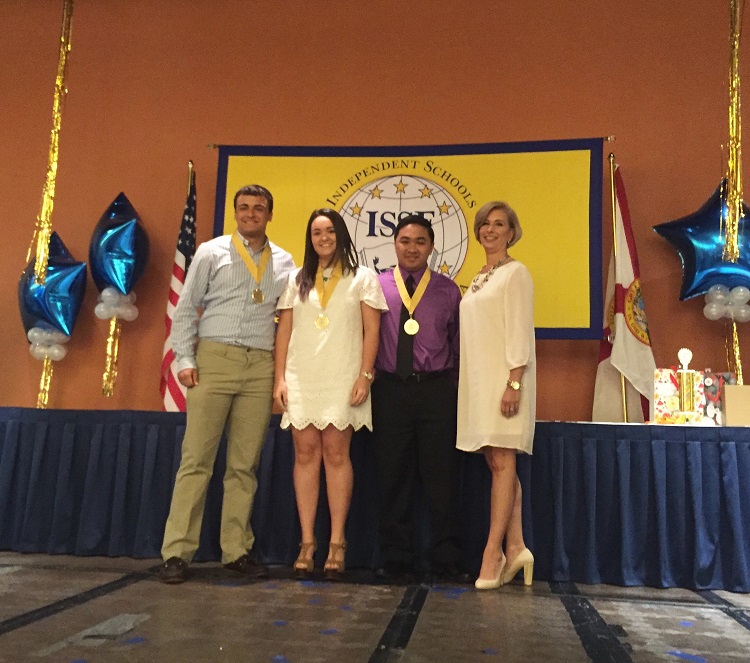 Msgr. Edward Pace High School students, from left, Kory Fleming, Samantha Bacerio, and Tristan Luzod stand on stage alongside Pace Principal Ana Garcia after receiving their Star Award medals at the 26th Annual ISSF Star Awards Luncheon April 20.