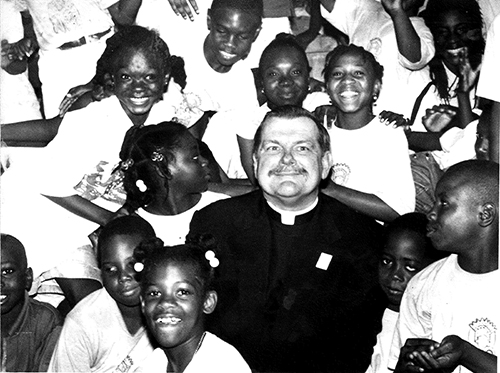 Archbishop - then Father - Thomas Wenski is surrounded by Haitian kids from Notre Dame d'Haiti Mission and the Pierre Toussaint Haitian Catholic Center in this file photo from the early 1990s.