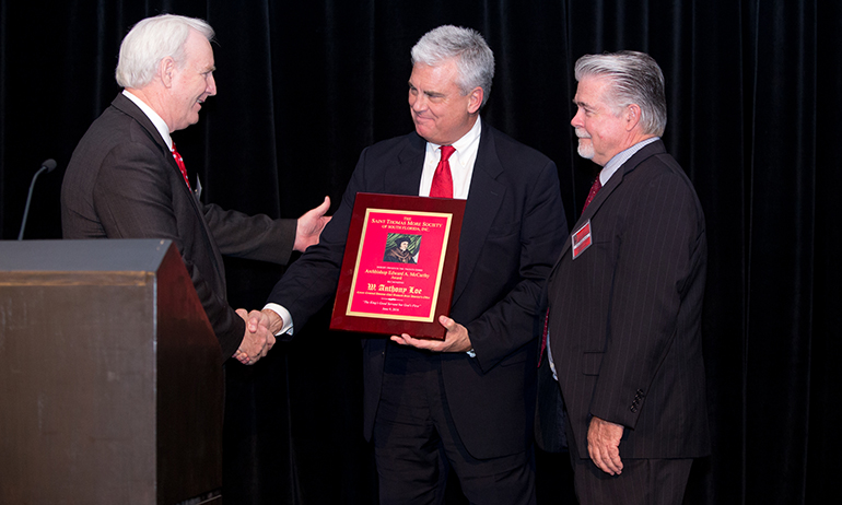 Robert M. Bulfin, left, president of the St. Thomas More Society of South Florida, presents the society's annual award to attorney Anthony "Tony" Loe, a prosecutor for the Broward County State Attorney's Office in Fort Lauderdale. At right is Judge Dennis Bailey.