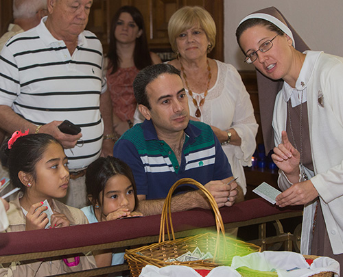 Sister Grace Heinrich, of the Servants of the Pierced Hearts of Jesus and Mary, explains the relics to Emma Crosa, 11, Anna Crosa, 8, and Andres Crosa.