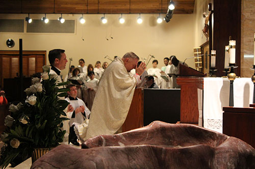 Archbishop Thomas Wenski prays before the Blessed Sacrament during Illuminare La Notte’s hour of adoration.