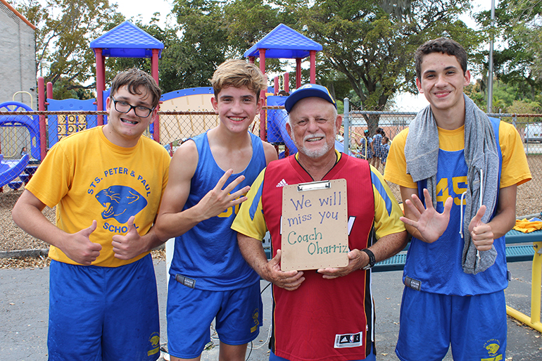 March 18, 2016
MIAMI

Eighth graders, from left, Julian Carballena, Dmitri Enriquez, and Gabriel Xirina pose with Coach William Oharriz after the blue vs. gold basketball game in his honor. Students gave the coach a thumbs-up, a 4 and a 6, and a clipboard to commemorate his 46 years of coaching at Sts. Peter and Paul School.