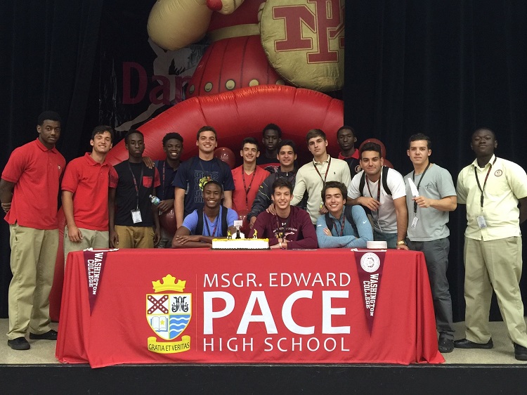 Surrounded by friends and teammates, Msgr. Edward Pace High School senior Armand Del Castillo signs his Letter of Intent to play basketball for Washington College.