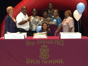 Msgr. Edward Pace High School basketball and flag football star Destiny Wilson poses for a photo with her family, coaches, and Pace Principal Ana Garcia (first on left) after signing a letter of intent to play basketball for St. Thomas University.