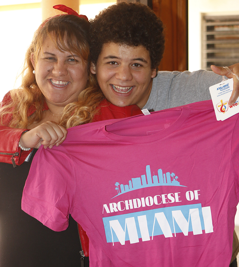 Showing off their enthusiasm and the South Florida pilgrims' Miami Vice-style T-shirt, from left, are San Isidro young adults Eileen Pinzas and Erick Frederick.