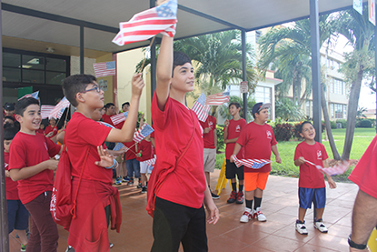 Agitando banderas de los Estados Unidos, los niños del campamento de verano de la escuela St. Michael the Archangel, en Miami les dieron la bienvenida a los niños del campamento de verano de la escuela St. Mary Cathedral, en Miami. Al centro Marc Calderón de 6to grado.