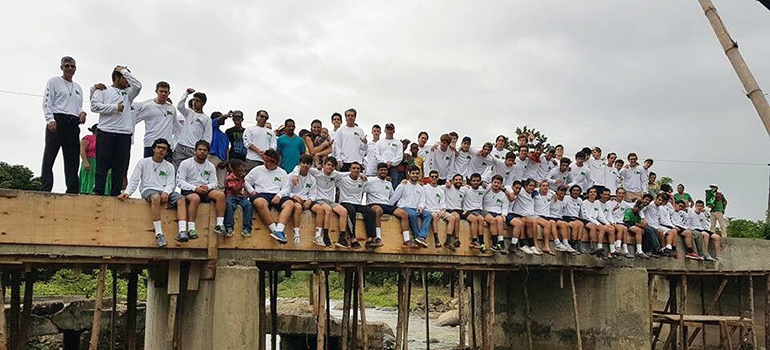 Missionaries from the 2016 Belen Youth Missions trip sit on top the bridge they built in the village of Batey, Piedra Blanca in the Dominican Republic.