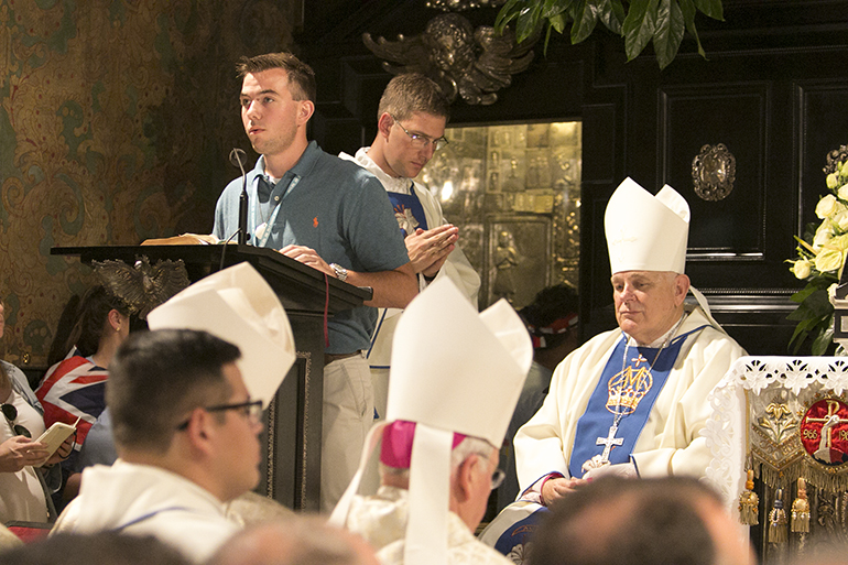 St. Sebastian parishioner and Cardinal Gibbons grad Marcus Mickey proclaims the second reading during the Mass as Archbishop Thomas Wenski listens.