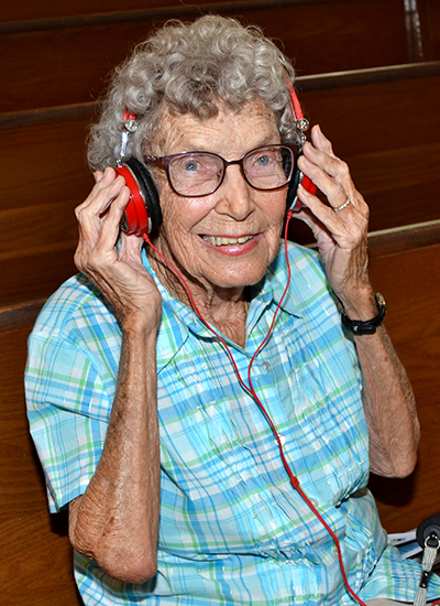 Nita Amsden shows one of the 10 headsets for those who need a little help to hear the Mass at St. Pius X.