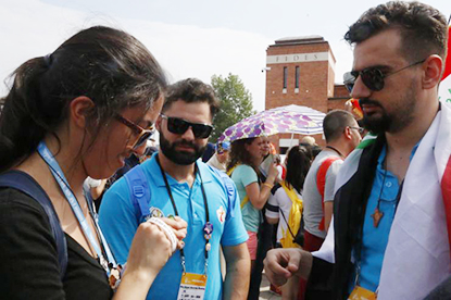 Julie Gonzalez, a member of St. Andrew Parish in Coral Springs and director of religious education at Mary Help of Christians in Parkland, exchanges trinkets with Chaldean Catholics from Iraq.