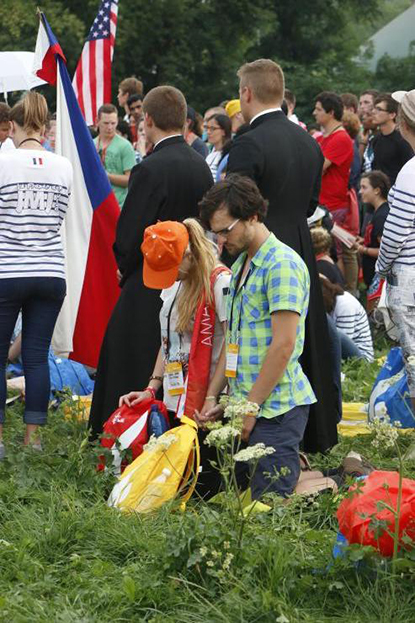 Pilgrims pray during Communion of the World Youth Day opening Mass at Blonia Park.