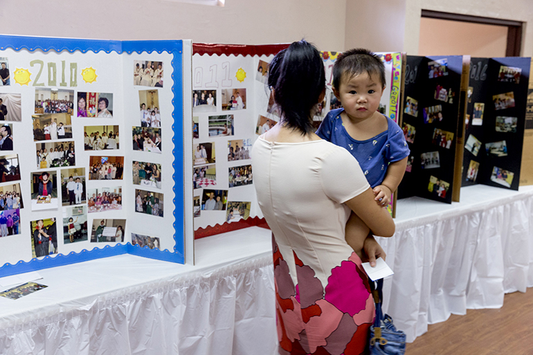 A mother and son explore a history display following an Aug. 14 Mass marking the 20th anniversary of the Chinese Apostolate of the Archdiocese of Miami. St. Jerome Parish in Fort Lauderdale hosted the Mass and luncheon.