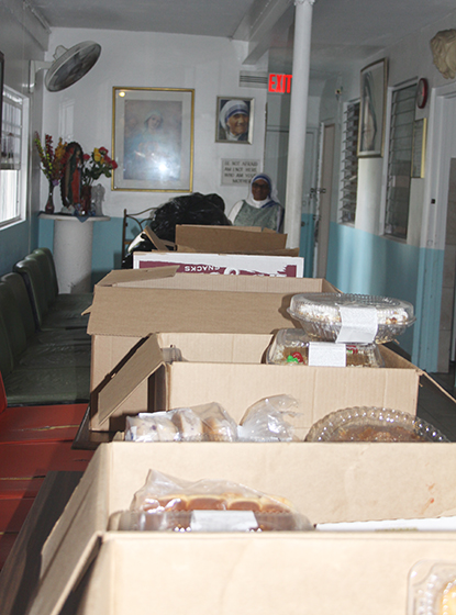 Sister Anthony stands behind the bounty of donated food that arrives daily at the Missionaries of Charity shelter in Miami, and which feeds the poorest of the poor on Miami's streets.