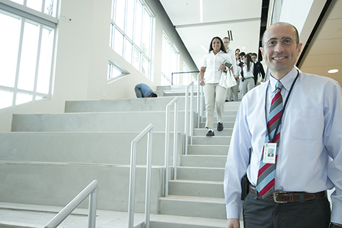 Jose Rodelgo-Bueno, St. Brendan High's principal, stands next to the "social stairs" in the new Innovation Center, where students can congregate before and after school and which can also serve as an impromptu auditorium.