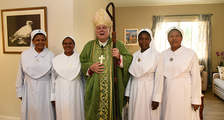 Archbishop Thomas Wenski poses with the four Holy Spirit Sisters from Mt. Kilimanjaro who now work at the Basilica of St. Mary Star of the Sea.